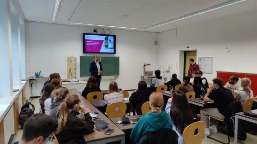 Prof. Lersch in einem Klassenzimmer vor Schülerinnen und Schülern