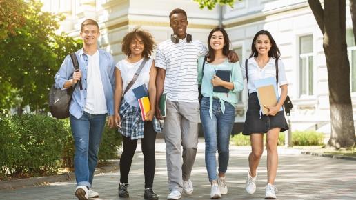 5 Studierende gehen gemeinsam über den Campus