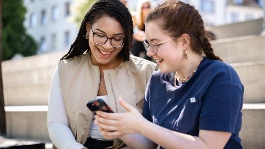 Studierende schauen gemeinsam ins Handy