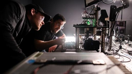 Zwei Männer schauen sich eine Computer gesteuerte Mechanik an
