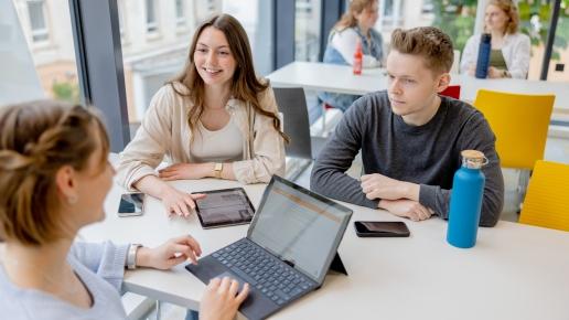 Foto mit drei Studierenden im Gespräch