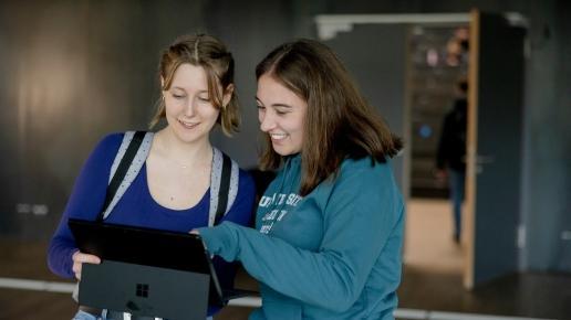 Studierende schauen gemeinsam in einen Laptop