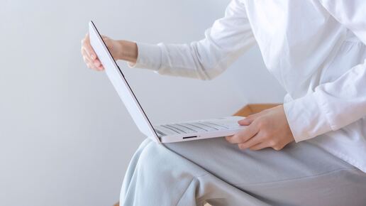 einer hat ein laptop auf den schoss und schaut drauf