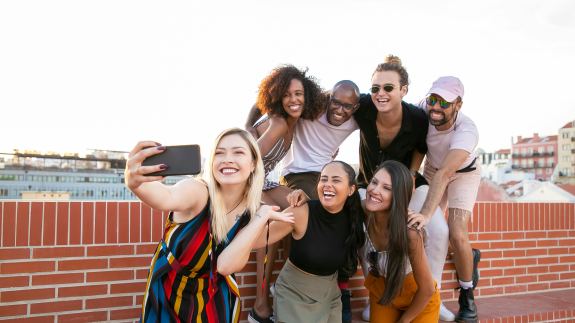 Eine Gruppe junger Menschen macht ein Selfie.