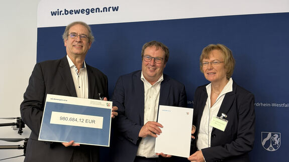 Prof. Strina, Minister Krischer und Uni-Rektorin Reese bei der Bescheid-Übergabe